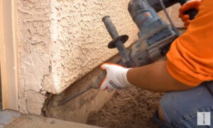Inspector checking anchor bolts for corrosion, rust, and signs of structural failure