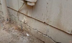 Homeowner reviewing DIY anchor bolt repair tools near a concrete foundation